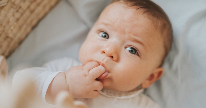 3-month-old baby is crying sucking hand
