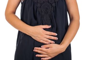 Pregnant woman gently holding her belly, symbolizing early pregnancy and reassurance despite symptoms of miscarriage